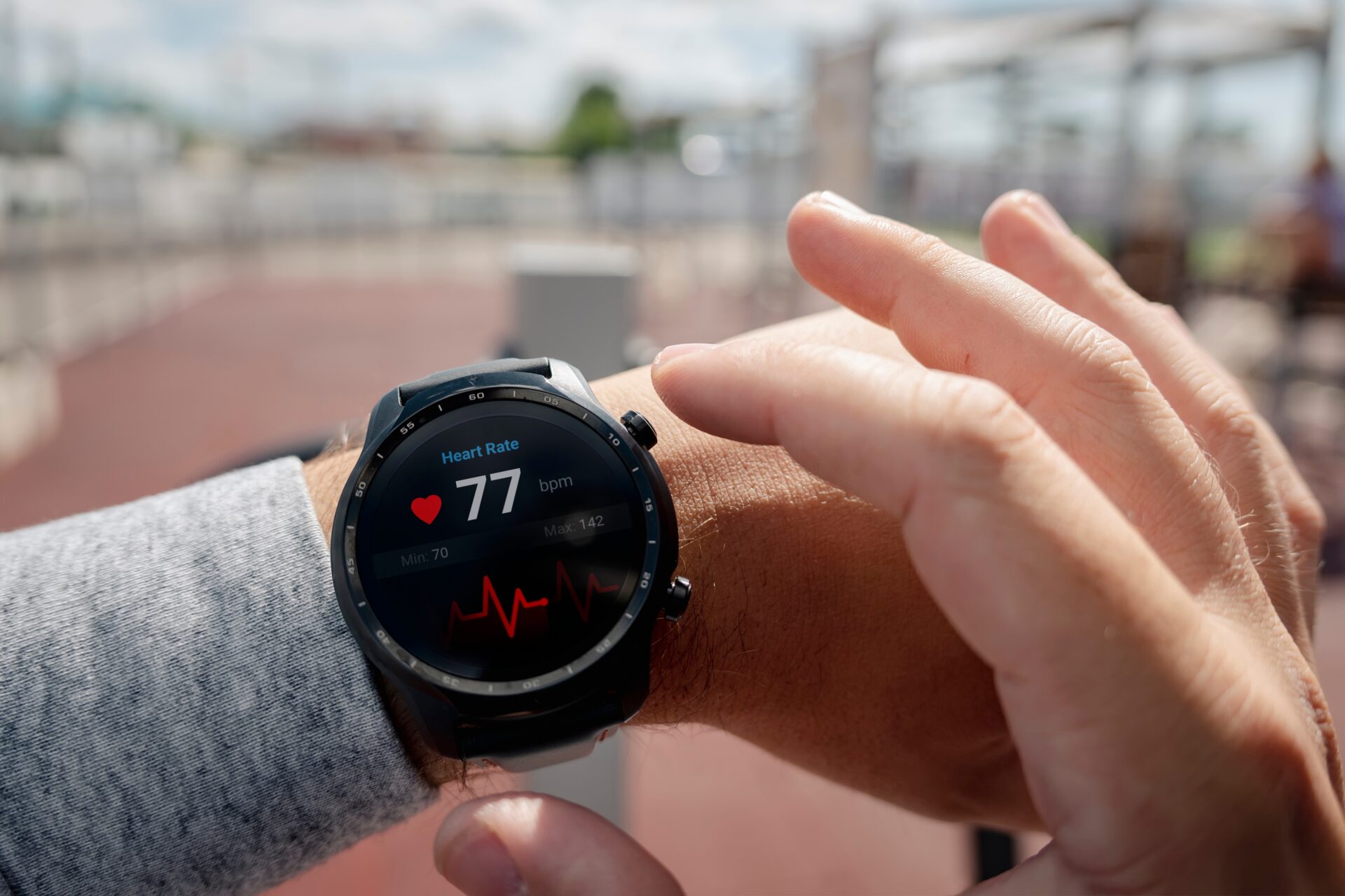 A close up view of a smart watch on a person's wrist displaying heart metrics