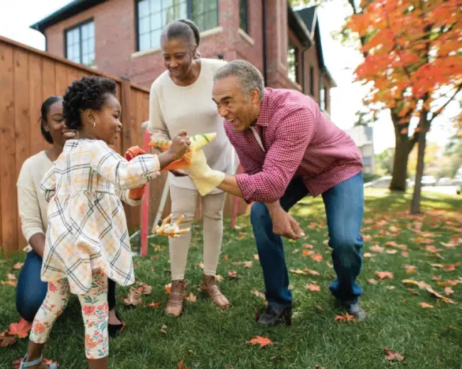 grandparents playing in yard with young girl child and girls' mother